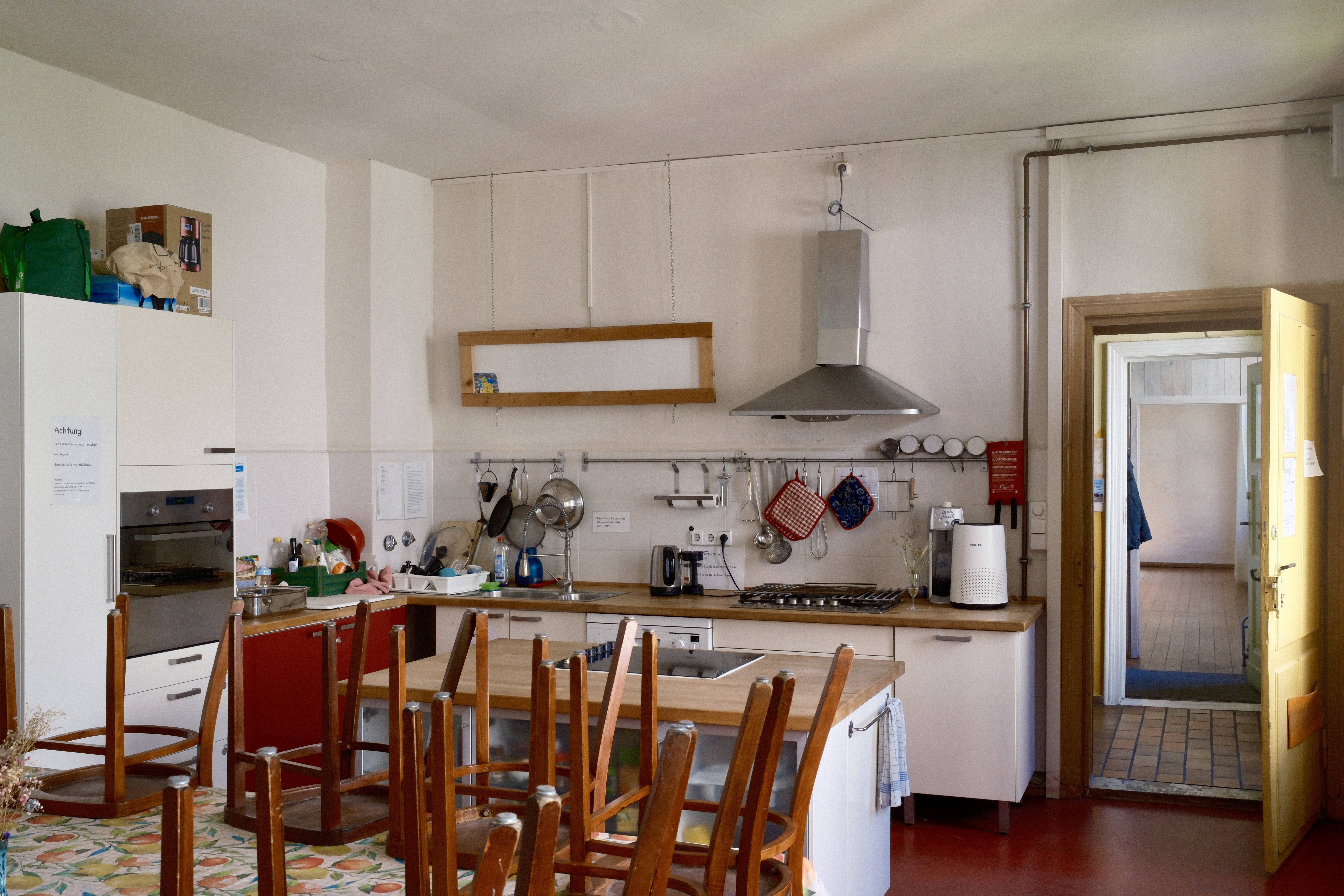 eine große, offene und helle Küche mit einem großen Esstisch und Stühlen