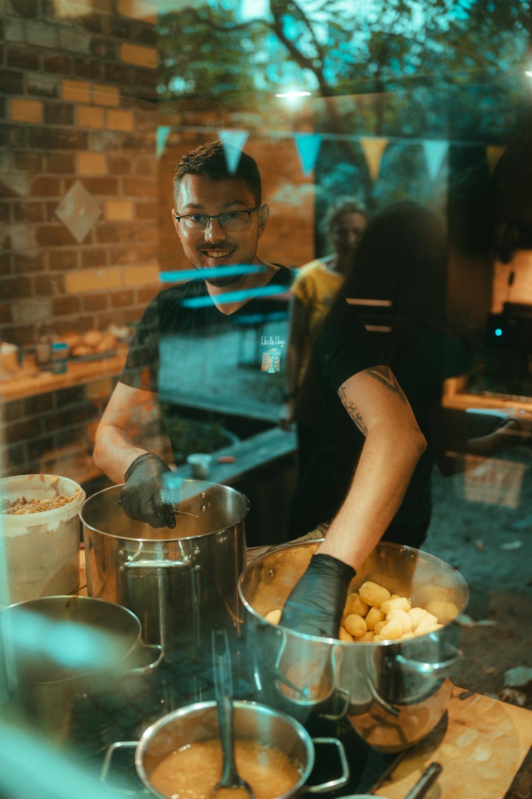 der Koch vom Vereinscafé steht am Herd, guckt aus dem Fenster und lächelt
